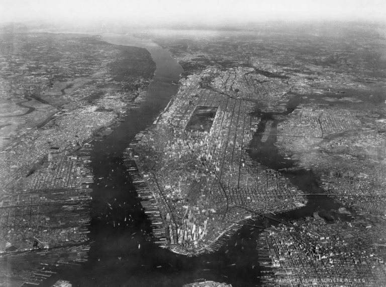 1928 aerial photograph of Manhattan showing the island, surrounding waterways, and dense urban development.