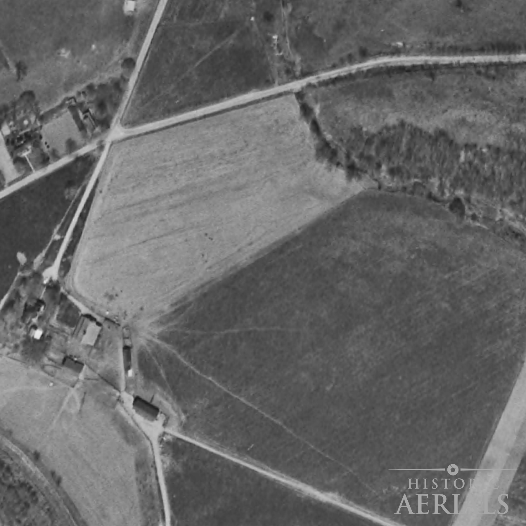 Historic aerial image of farmland and road alignments near the Junction Earthworks site in Ross County, Ohio, showing landscape conditions in 1960.