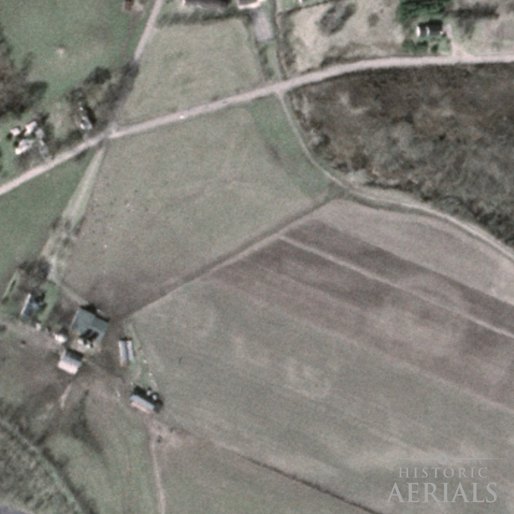 Historic aerial image of farmland and road alignments near the Junction Earthworks site in Ross County, Ohio, showing landscape conditions in 1985.