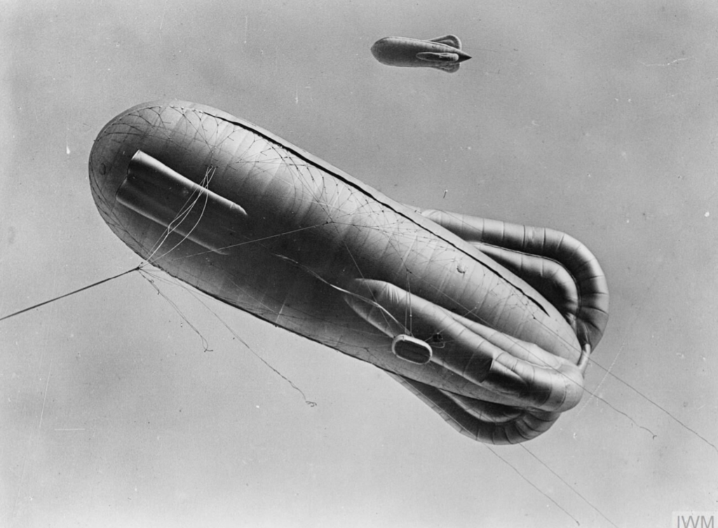 World War I Caquot kite balloon in flight, showing stabilizing lobes and tether lines used for aerial reconnaissance and artillery observation.