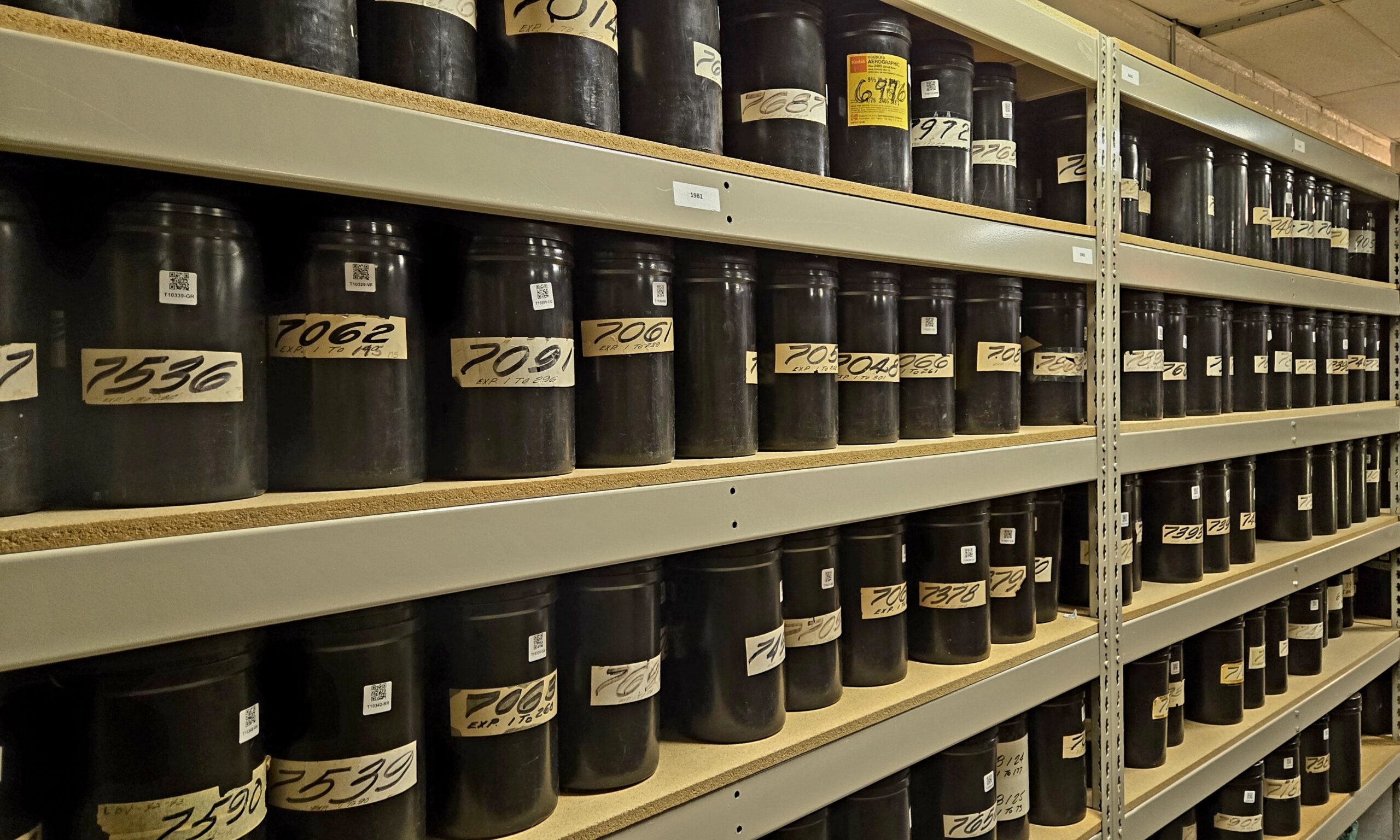 Shelves filled with labeled aerial film containers from Tobin Aerial Surveys in the Historic Aerials collection.