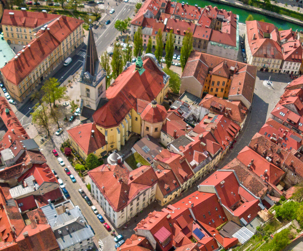 Aerial view of the Church of St. James (Šentjakobska cerkev) and surrounding rooftops in Ljubljana, Slovenia.