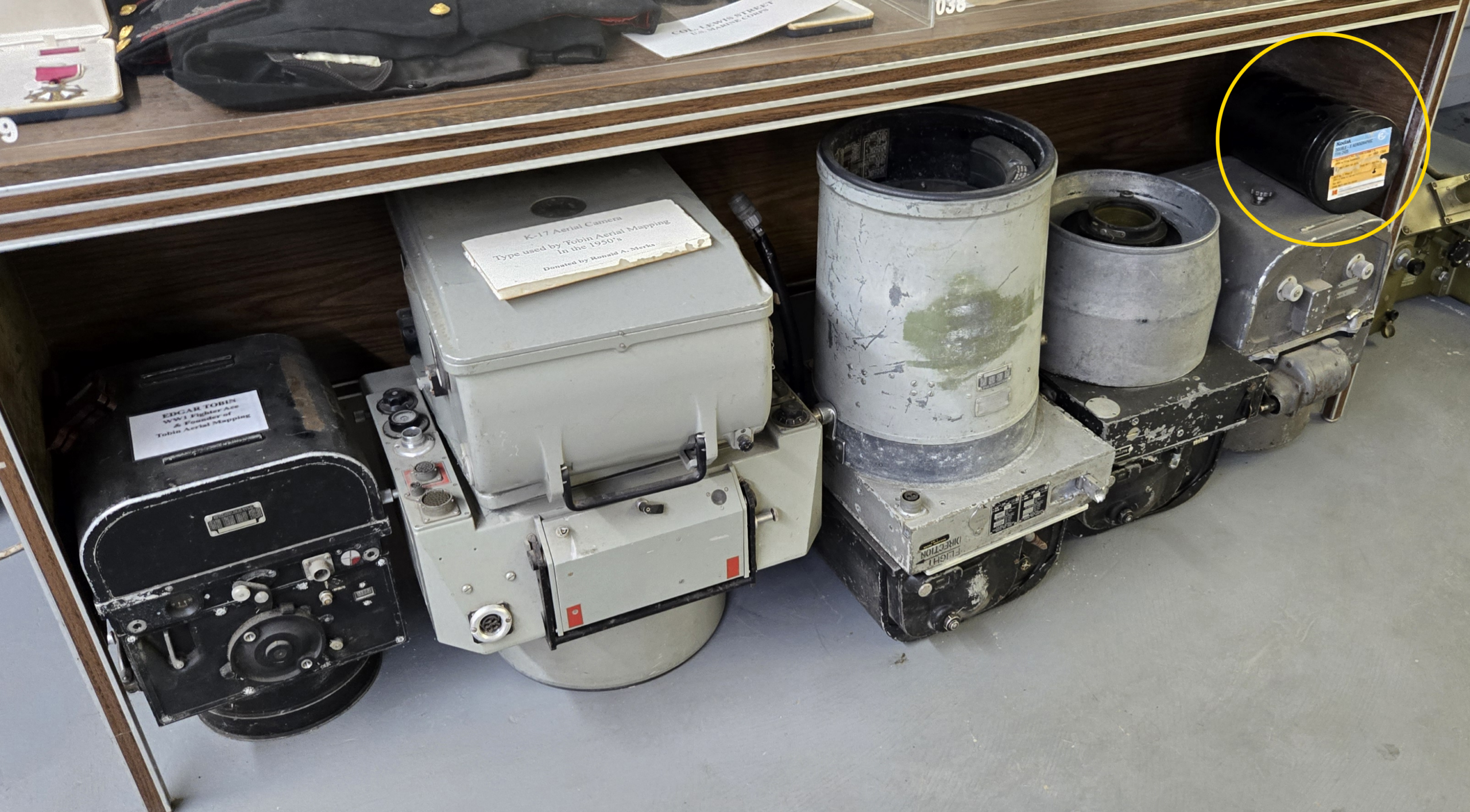 Aerial survey cameras from Tobin Aerial Surveys displayed alongside a Kodak film container at a museum.